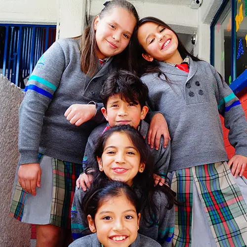 Niños sonrientes con uniforme en primaria particular de Cuautitlán Izcalli, mostrando compañerismo y valores educativos en CBA